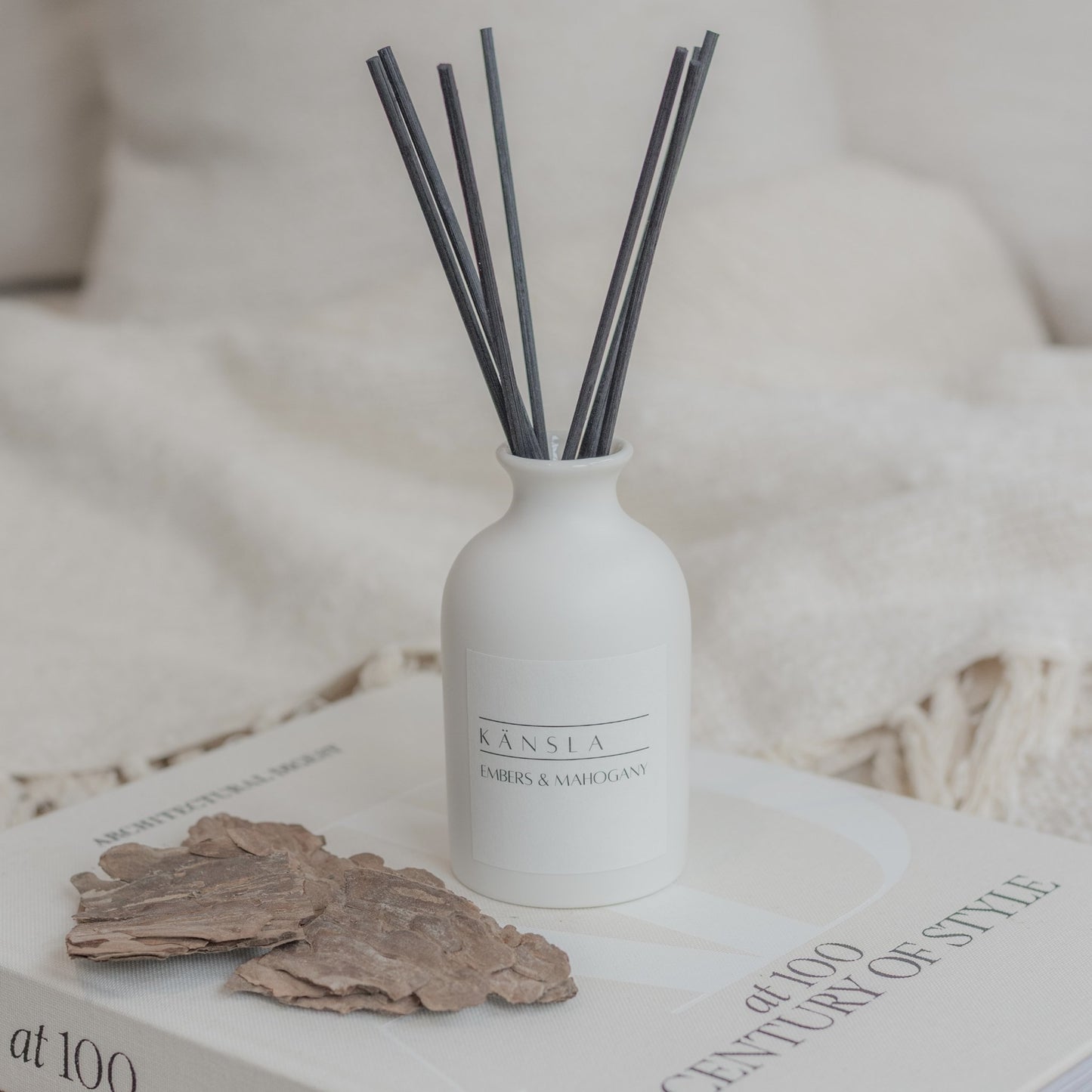 White ceramic reed diffuser with black reeds in embers and mahogany scent