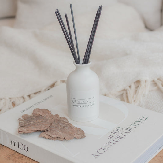 White ceramic reed diffuser with black reeds in embers and mahogany scent