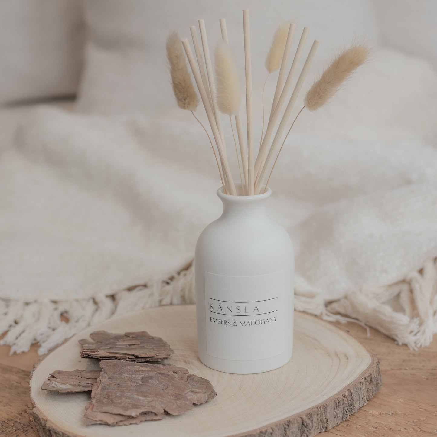 White ceramic reed diffuser with natural reeds in embers and mahogany scent