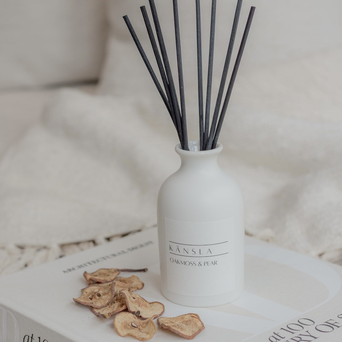 White ceramic reed diffuser with black rattan reeds oakmoss and pear