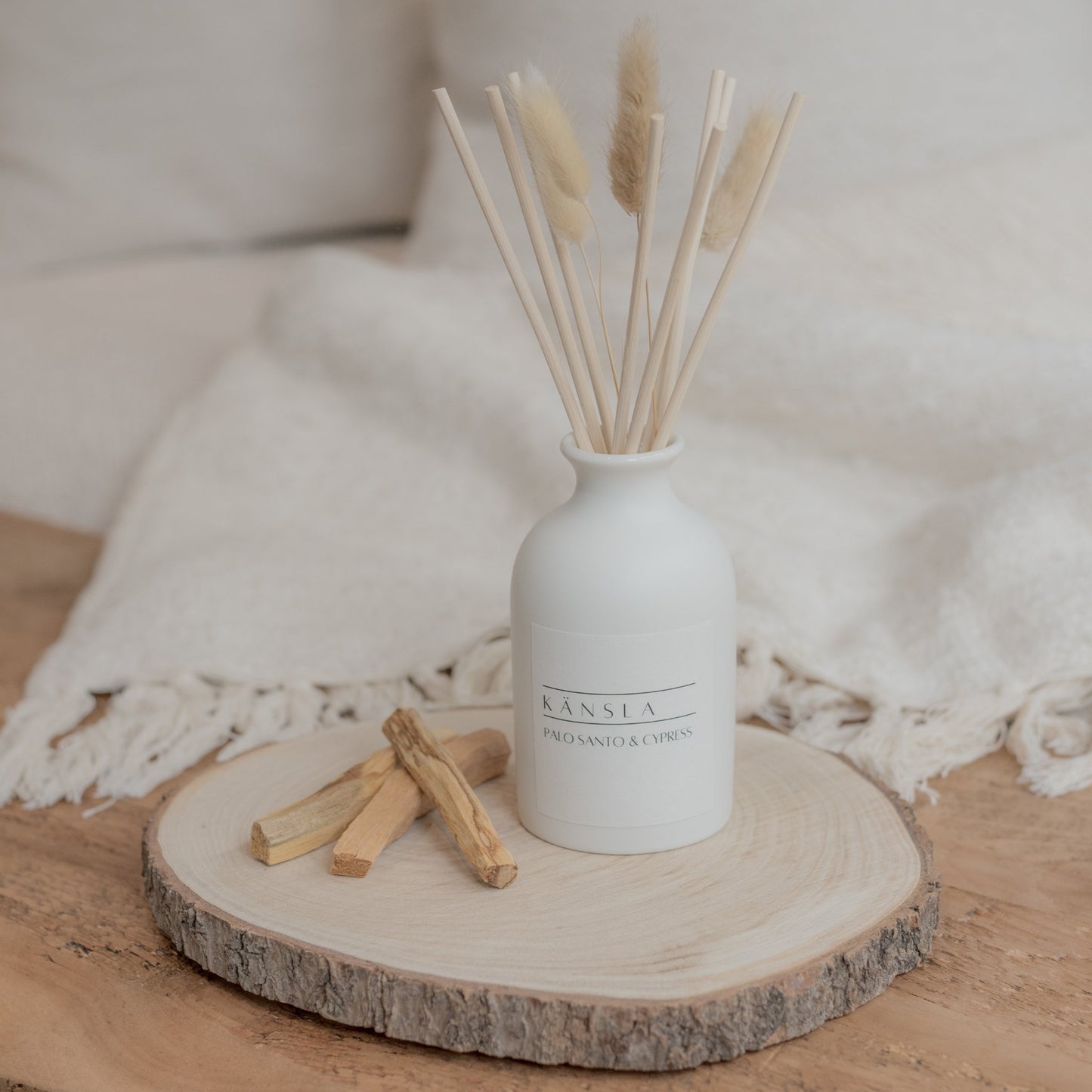 White ceramic reed diffuser with natural reeds and dried bunny tails palo santo & cypress
