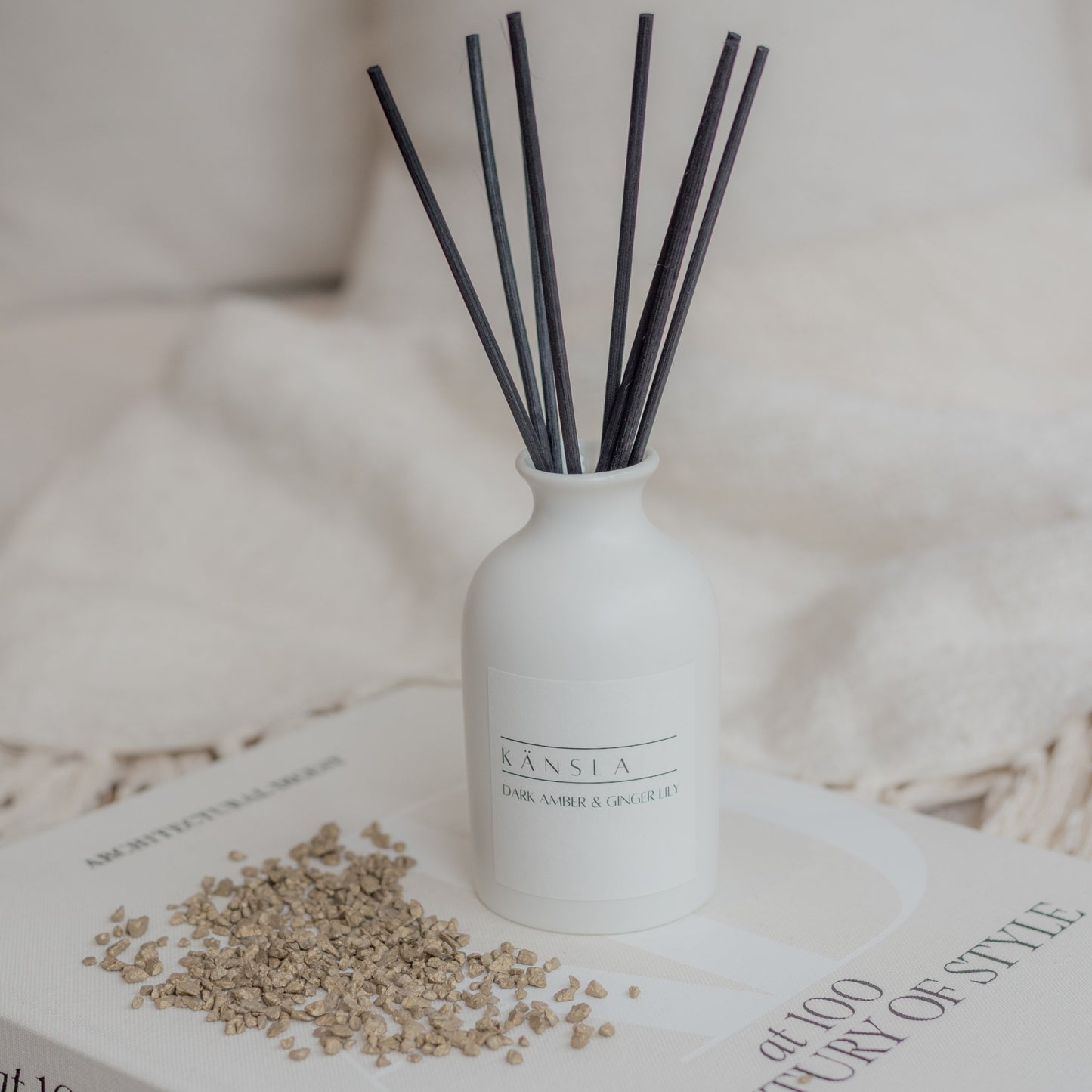 Close up of dark amber ginger lily reed diffuser with black rattan reeds