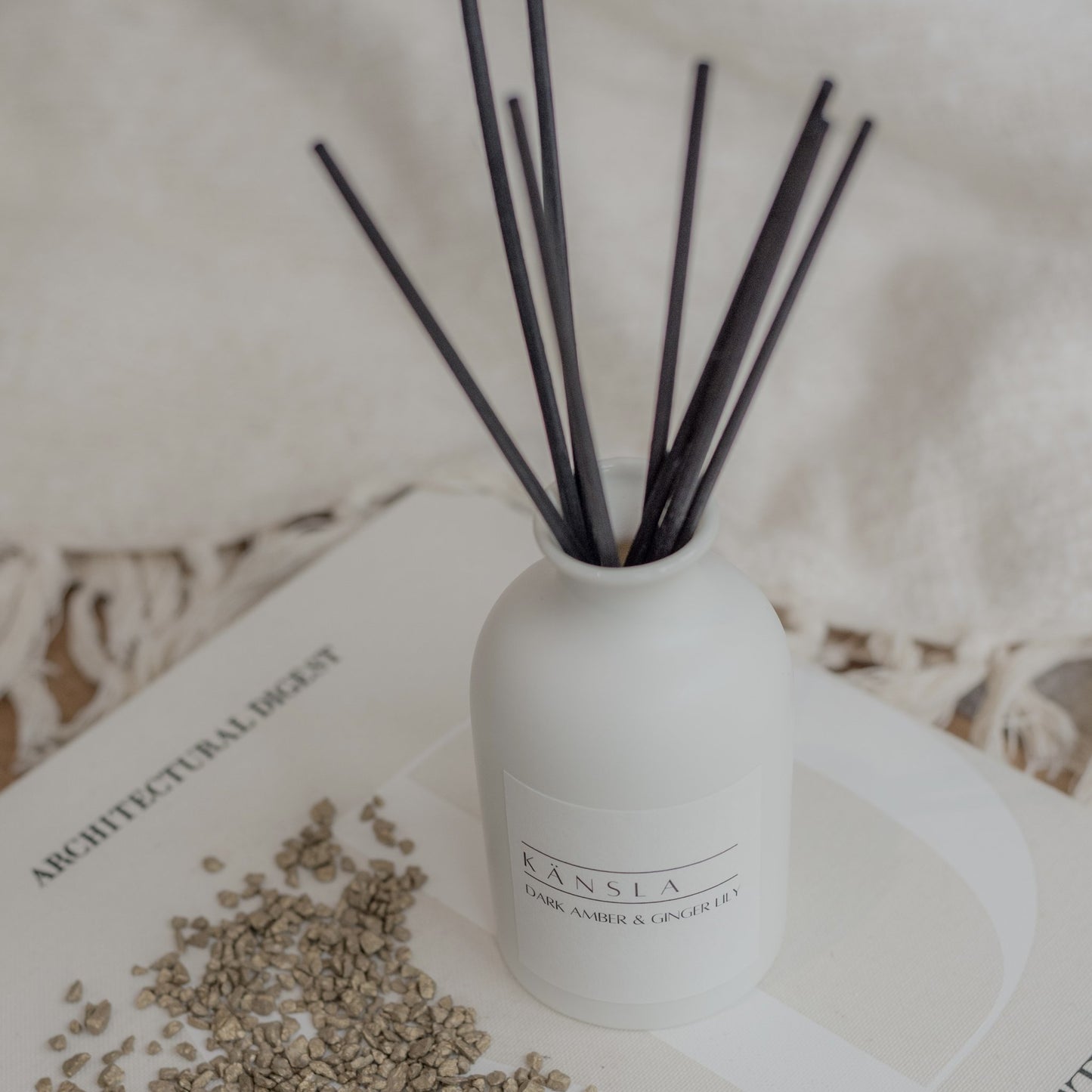 Close up of dark amber ginger lily reed diffuser with black rattan reeds