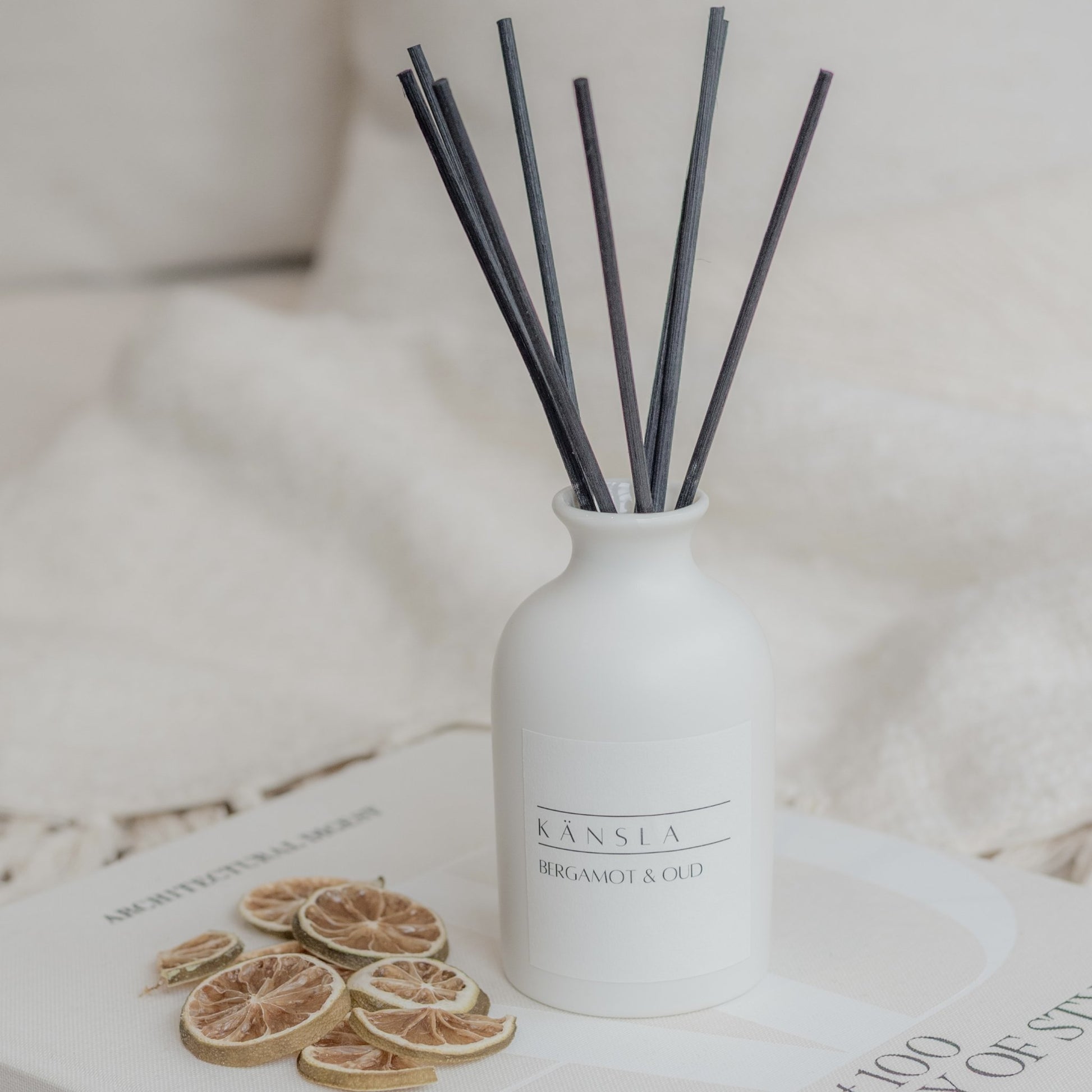 White ceramic reed diffuser with black rattan reeds bergamot and oud