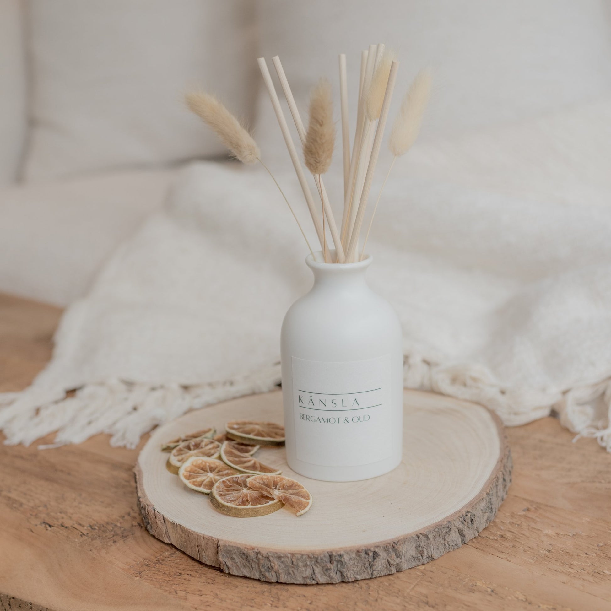 White ceramic reed diffuser with natural rattan reeds and dried bunny tail decoration bergamot and oud