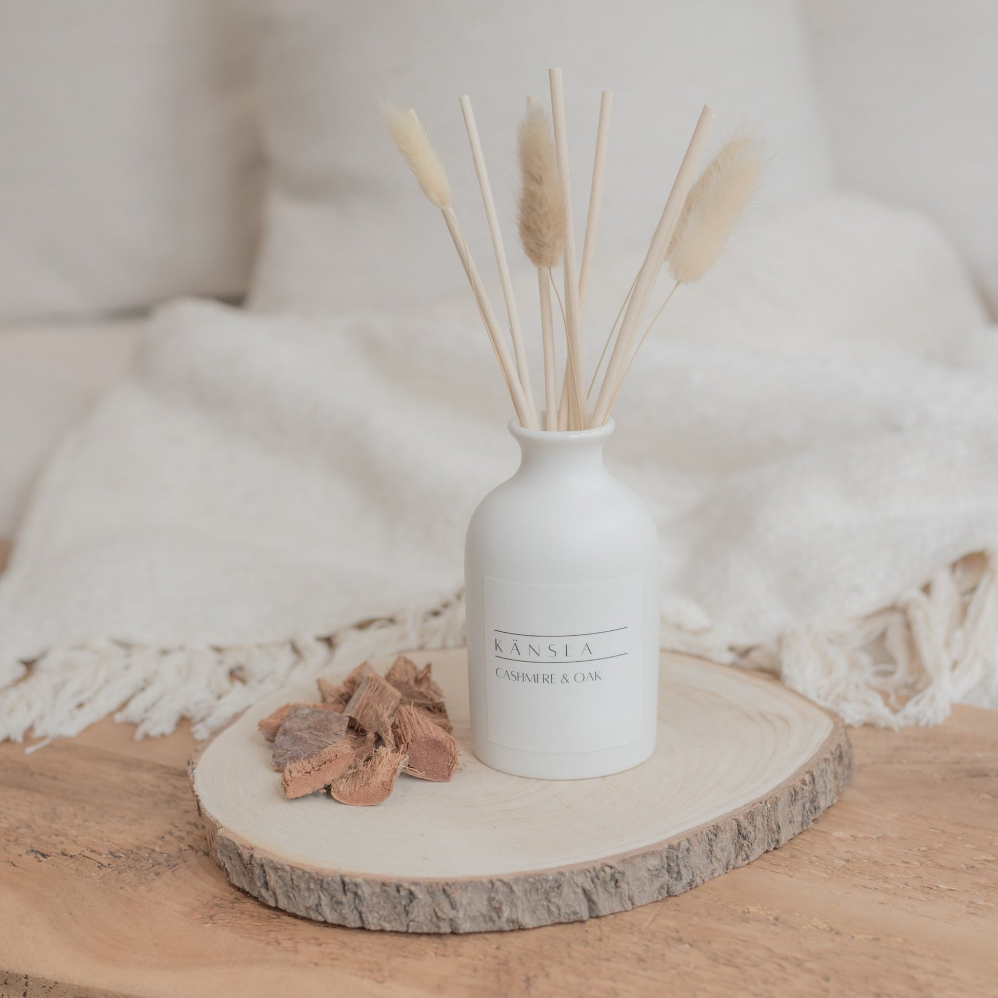 White ceramic reed diffuser with natural reeds and dried bunny tails cashmere and oak