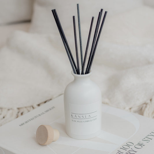 White reed diffuser with black rattan reeds and white label kansla tuscan leather and oud